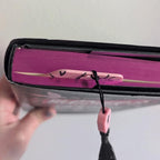 Bookmark in book being held by hand on a white background.