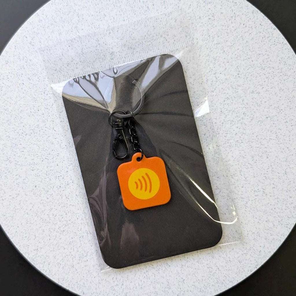 Packaging for keychain on a white circular background. 