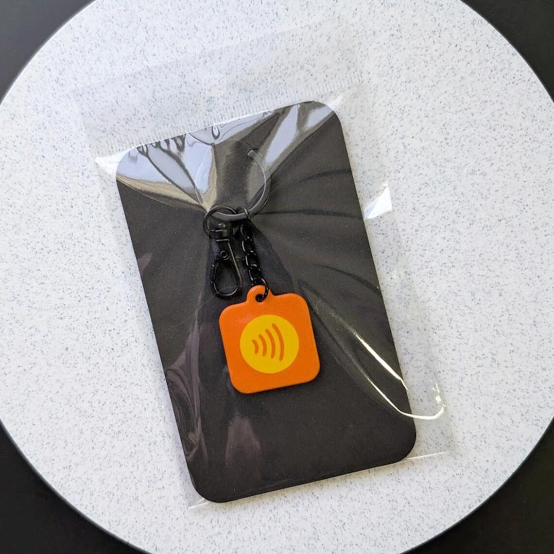 Packaging for keychain on a white circular background. 