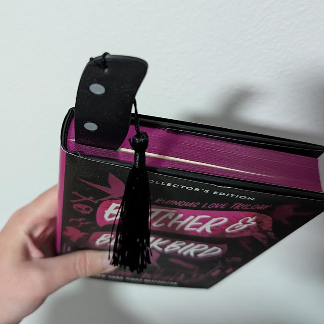 Book with a tassel bookmark held by a hand on a white background