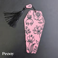 Pink coffin bookmark with floral patterns and a black tassel on a dark background