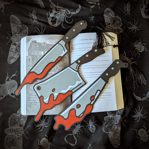 Decorative book with bookmarks on a dark fabric background with insect illustrations.