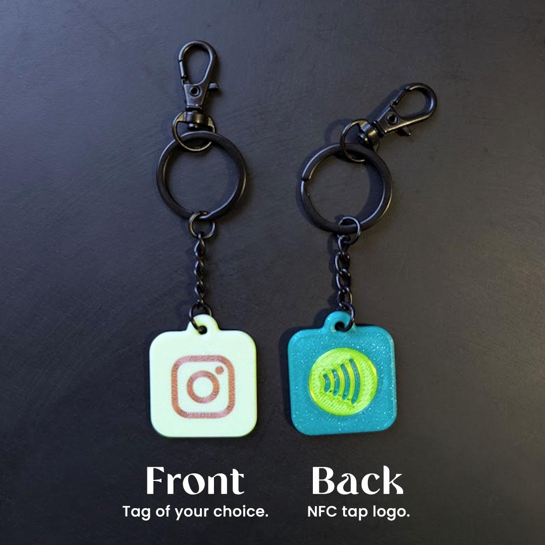 Two keychains with different logos on a dark background